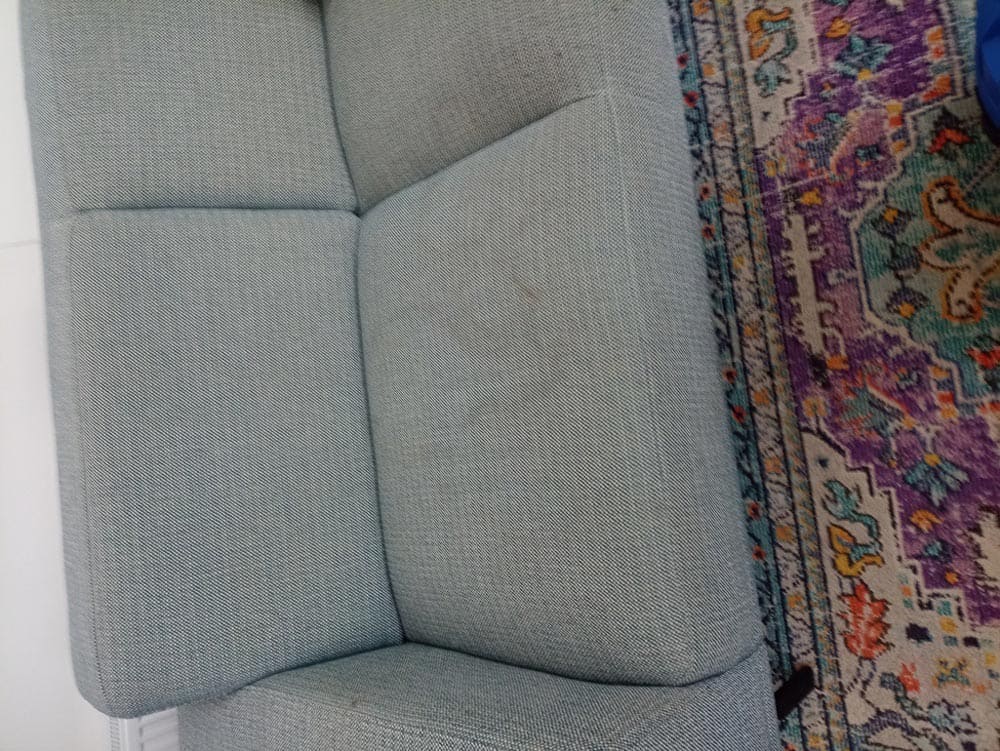 Donkergrijze hoekbank vóór de reiniging – vaal en grauw door huidvet en dagelijks gebruik