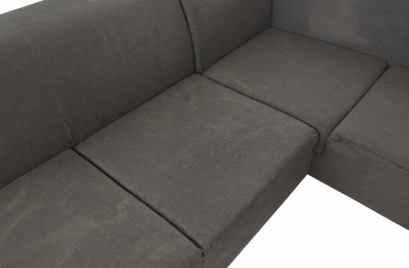 Donkergrijze stoffen bank met etensvlekken en slijtage in Simpelveld vóór reiniging